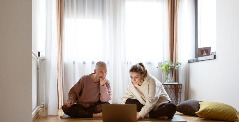 two women reading online sharing a computer