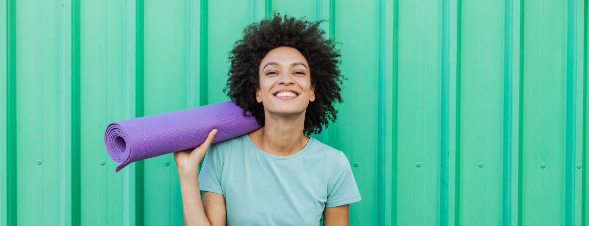 woman holding yoga mat