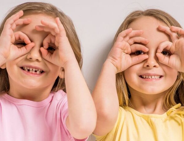 2 girls making finger eyes