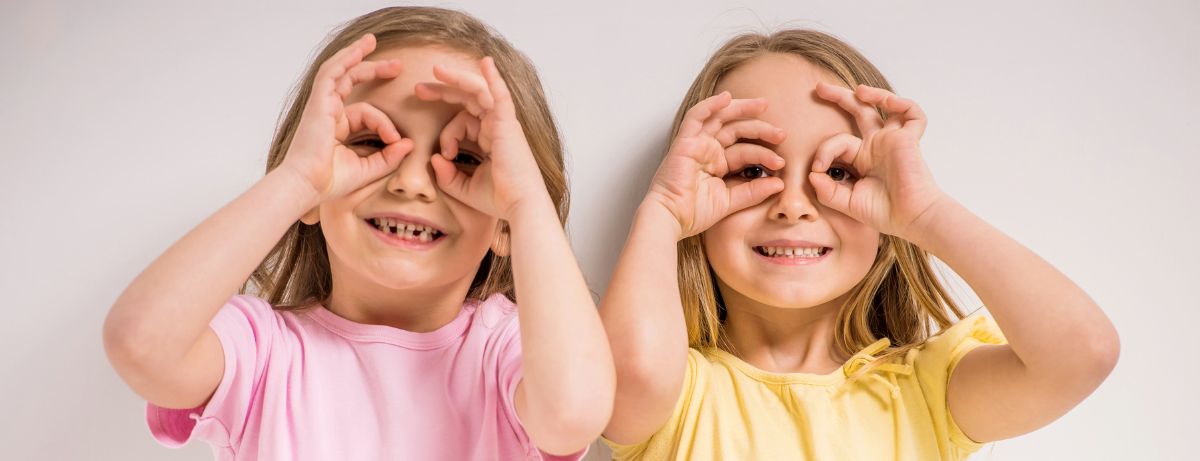 2 girls making finger eyes