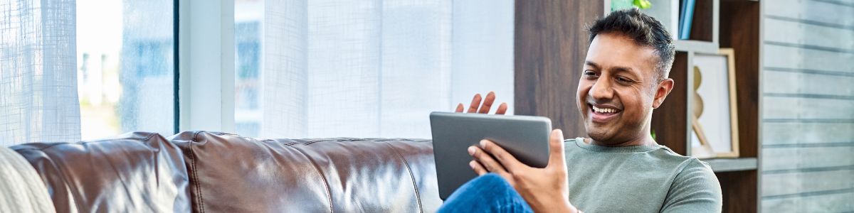 man on couch using tablet